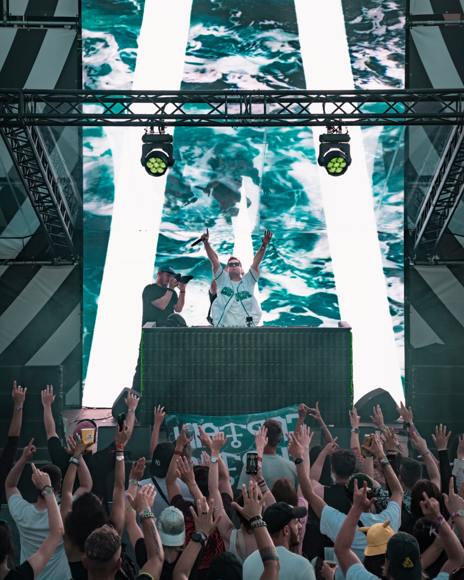 Captain Curtis with arms raised above a festival crowd